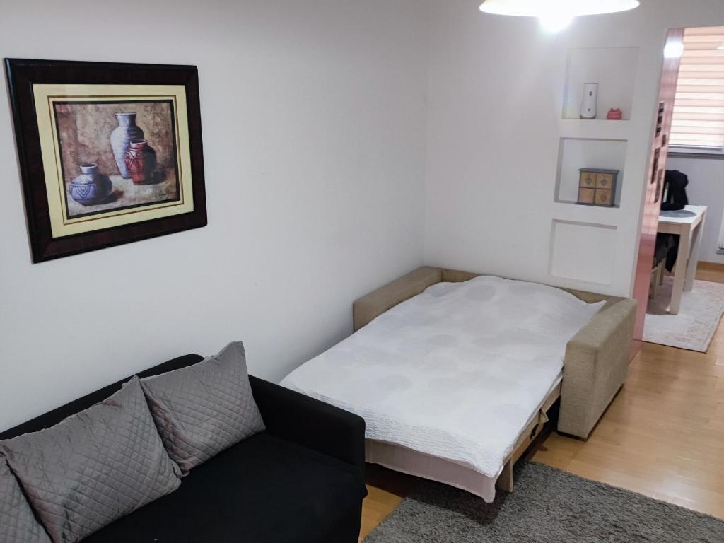 une petite pièce avec un lit et un canapé dans l'établissement Amna, à Sarajevo
