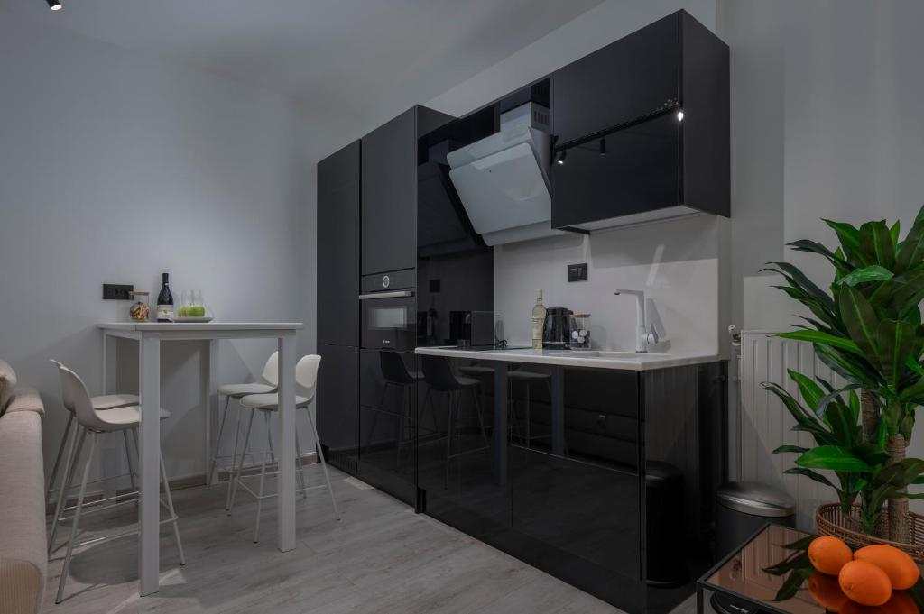 a kitchen with black cabinets and white counter tops at Embassy Elegant Suite in Thessaloniki