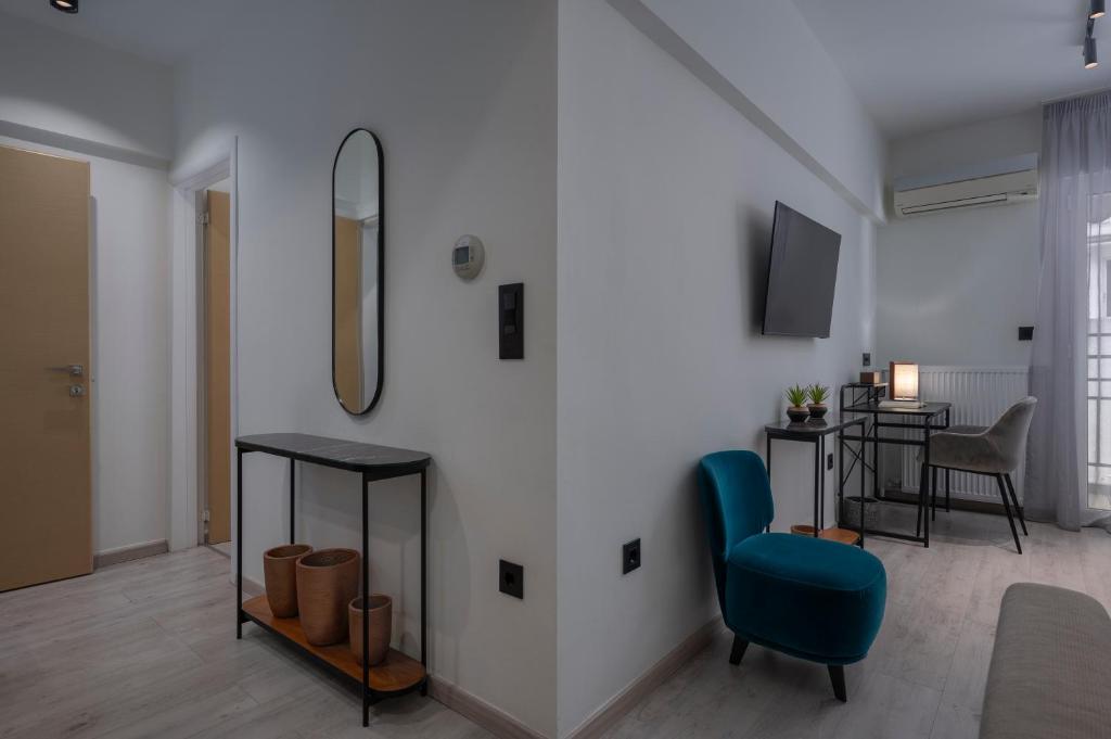 a living room with a blue chair and a table at Embassy Elegant Suite in Thessaloniki