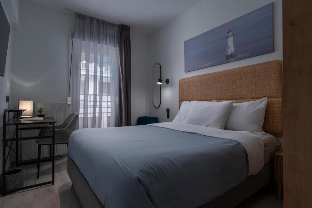 a bedroom with a bed and a desk and a window at Embassy Elegant Suite in Thessaloniki