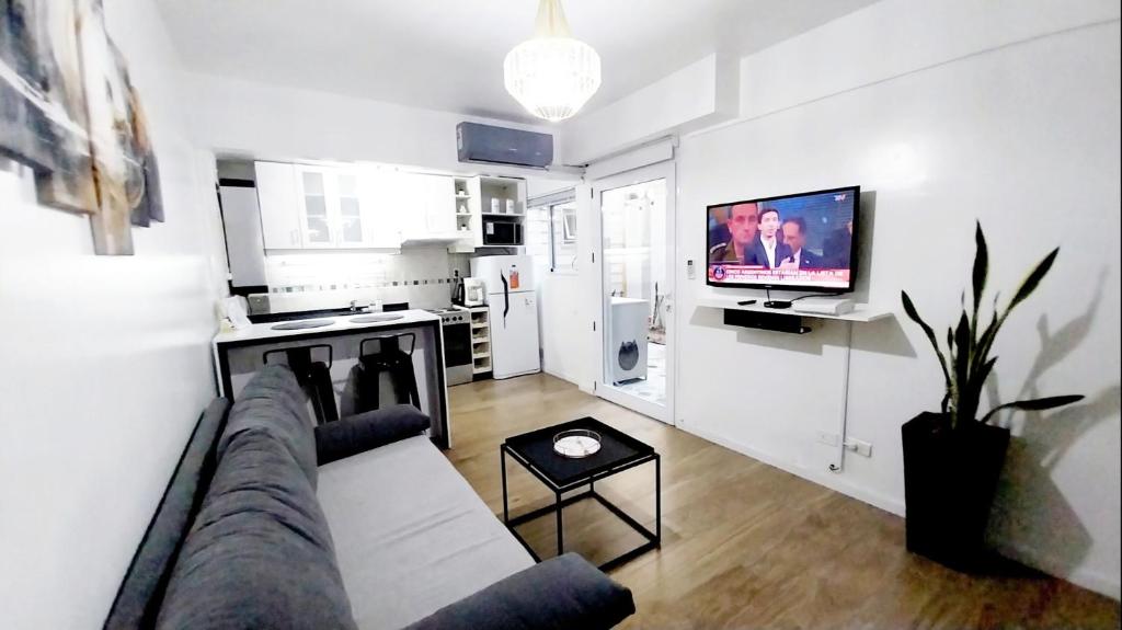 a living room with a couch and a tv at Apartamento moderno en Las Cañitas, Palermo in Buenos Aires