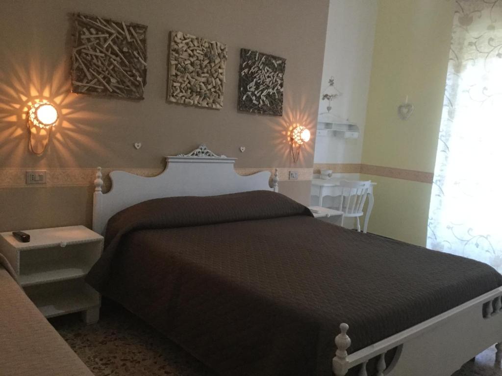 a bedroom with a bed and two pictures on the wall at Il Melangolo in SantʼAntìoco