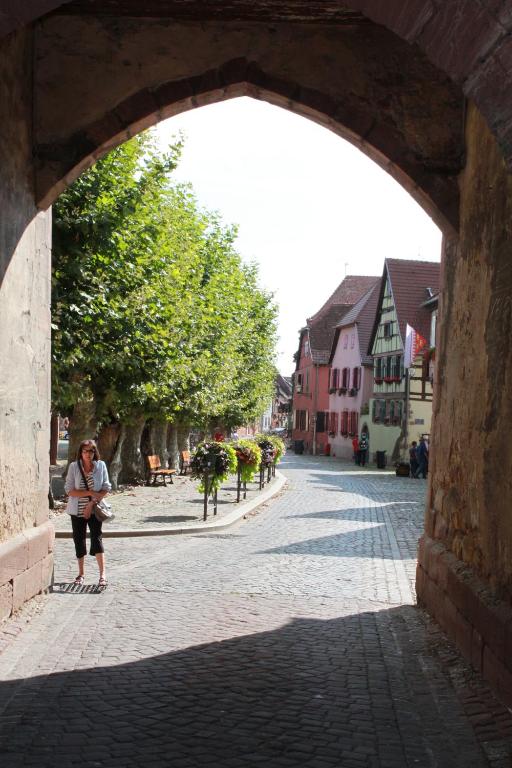 a woman walking through an archway on a street at s'Harzala Vert in Bergheim