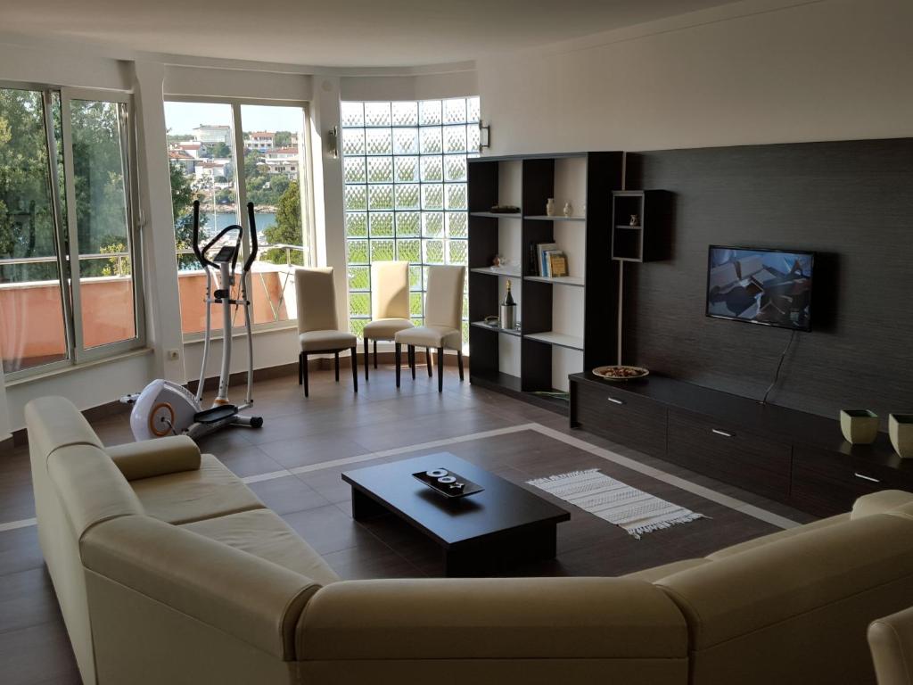 a living room with a couch and a table at Apartments Seafront Villa in Pula