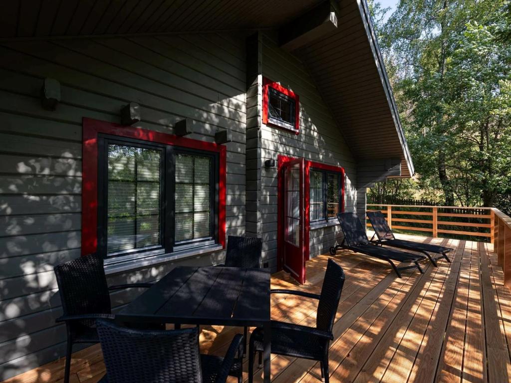 a porch of a house with a table and chairs at Lodge in Buntenbock in Flussnähe in Clausthal-Zellerfeld