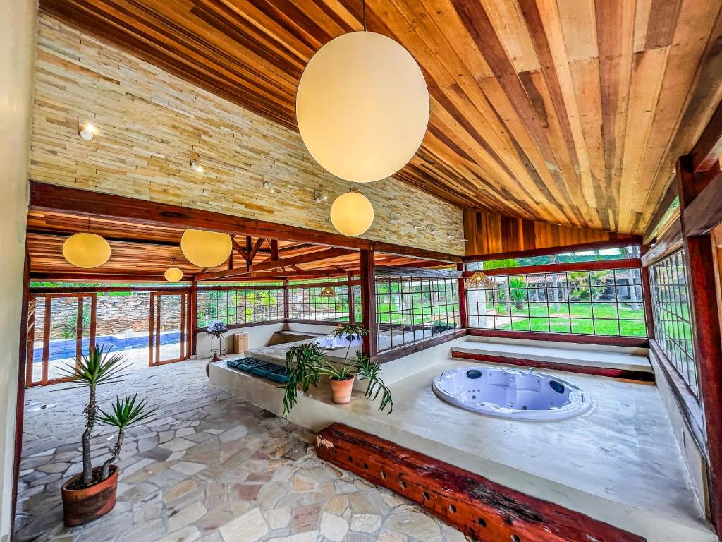 a large room with a hot tub and windows at Pousada Sete Quedas in Carrancas