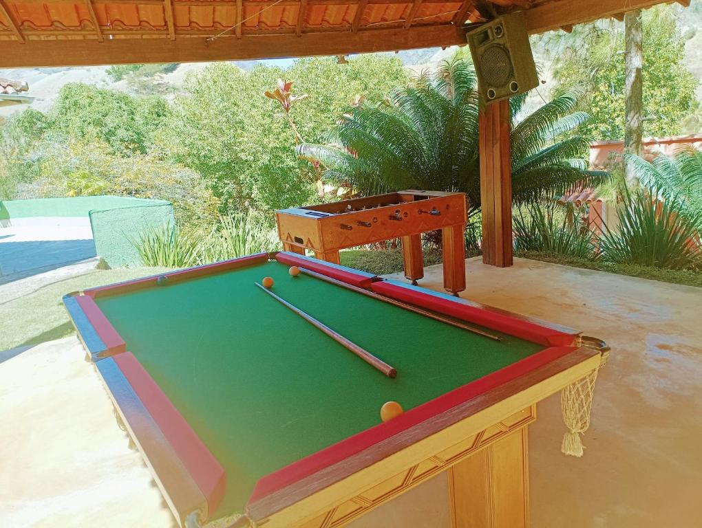 a pool table with two bats on top of it at Sitio maravilharara in Miguel Pereira
