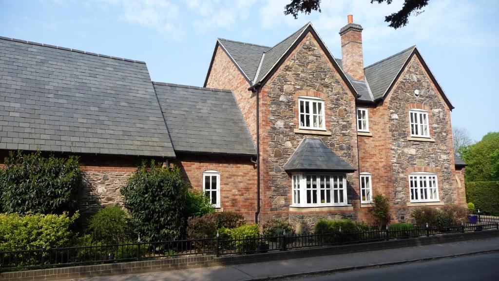 an old brick house with a black roof at Keepers Lodge in Swithland