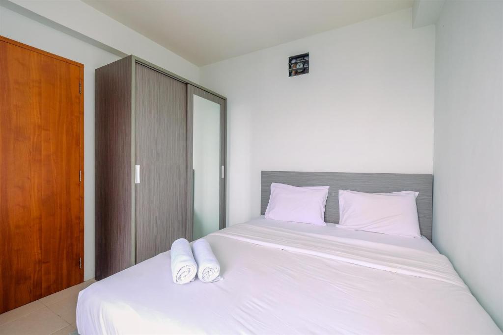 Una cama o camas en una habitación de Combined 2BR with Study Room Titanium Square Apartment By Travelio
