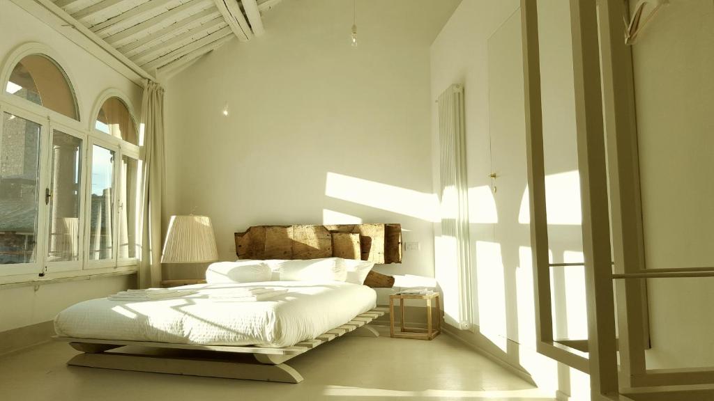 a white bedroom with a bed and a window at B&B A Piazza del Gesù in Viterbo