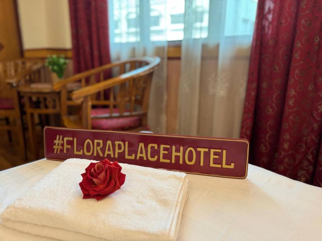 a sign on a table with a rose on a napkin at Flora Place Hotel in Kota Bharu