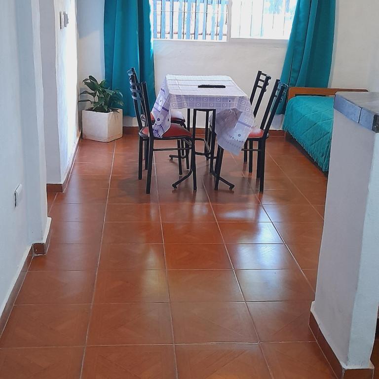 a dining room with a table and chairs on a tile floor at Todo cerca in Mina Clavero