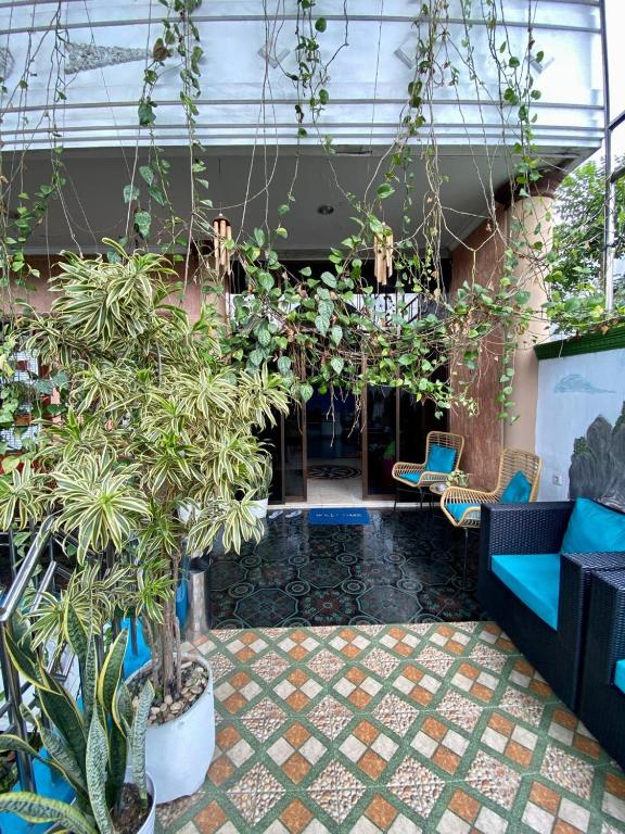 una hall con piante e sedie in un edificio di MADOR Malang Dorm Hostel a Malang