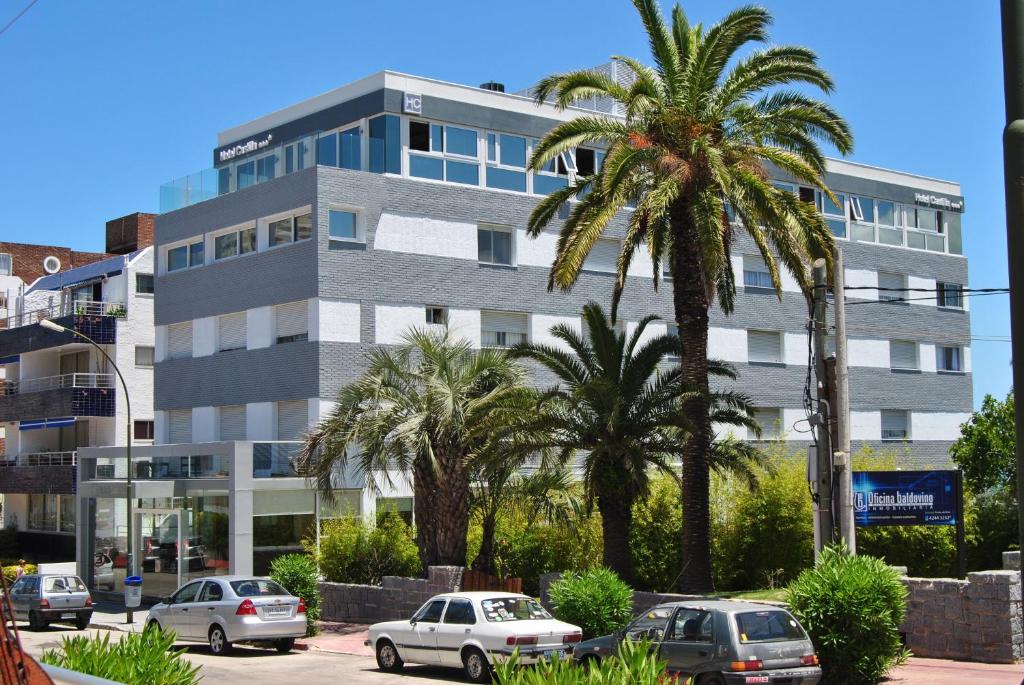 un edificio con coches estacionados frente a él en Hotel Castilla, en Punta del Este