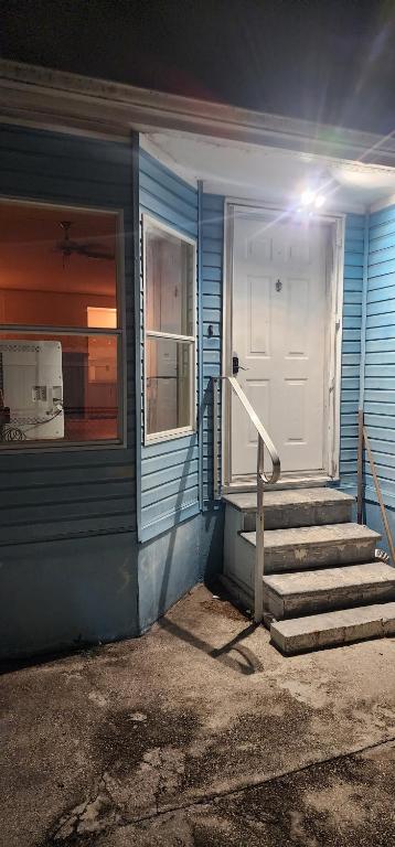 una casa azul con una puerta blanca y escaleras en 1233 Apartment 4 Miami, en Tamiami