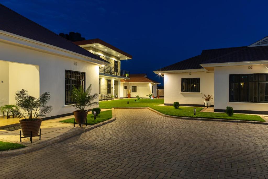 ein Haus mit einer gepflasterten Auffahrt davor in der Unterkunft Sarita Village Homes in Arusha