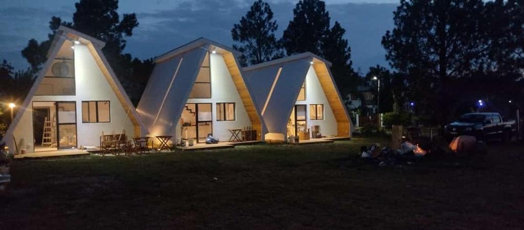 a house with two triangular roofs at night at Lapachos blco cabañas in Federación