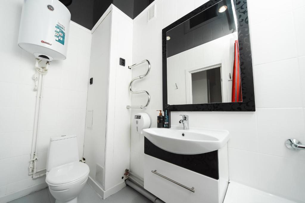 a bathroom with a toilet and a sink and a mirror at Люкс Крупская 78 in Pavlodar