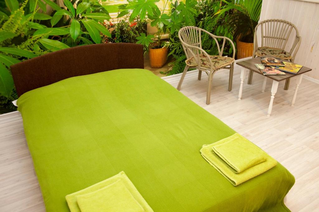 a green blanket sitting on top of a table at Hotel Planernaya in Domodedovo