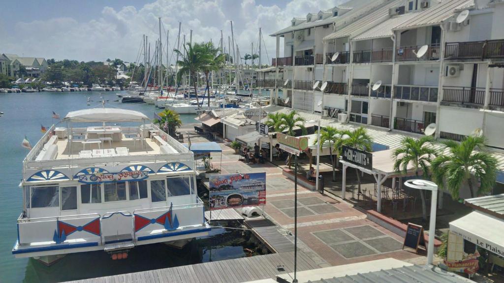 a boat docked in a marina next to buildings at Joli Studio Vue Sur Mer in Pointe-à-Pitre