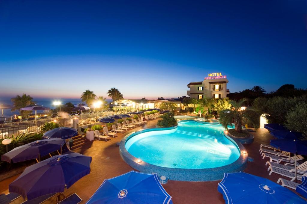una piscina con sombrillas y sillas y un hotel en Hotel Terme Providence, en Isquia