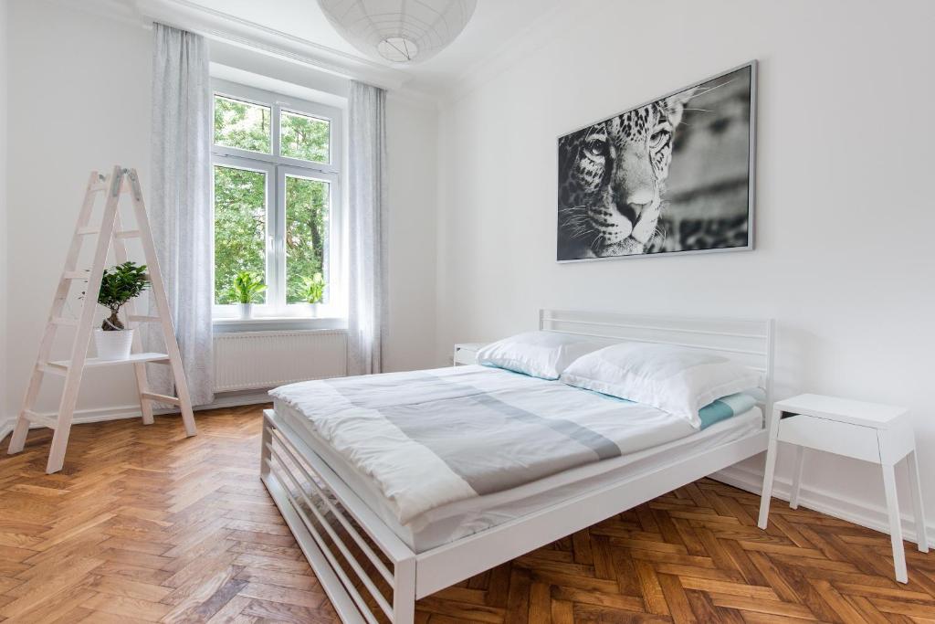 a white bedroom with a bed and a desk at Style4rent Sunny Old Town Apartments in Krakow