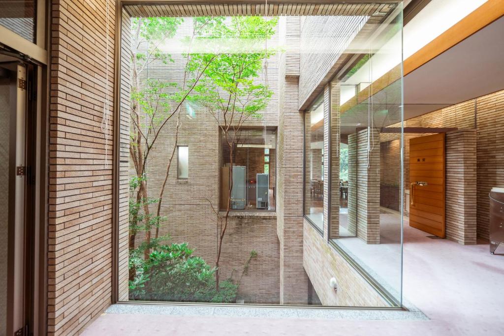 a glass pivot door opens onto a courtyard at 熱海山荘 in Atami