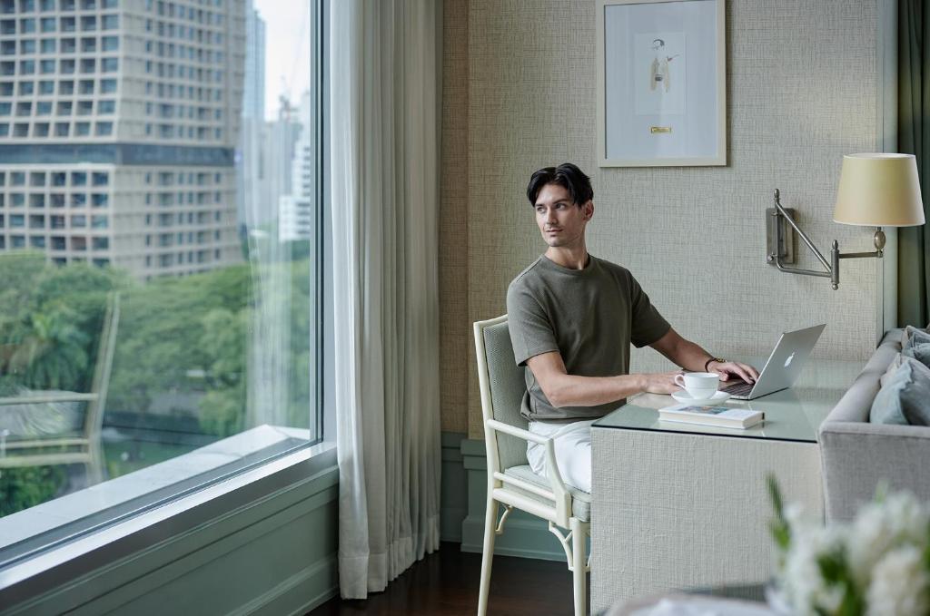 A compact in-room work setting beside a large city-facing window.
