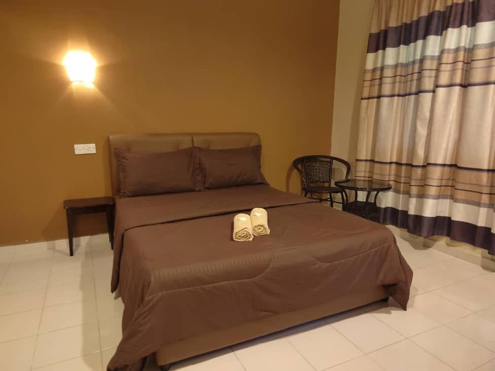 a bedroom with a bed with two shoes on it at Four F Motel by Lily in Pantai Cenang