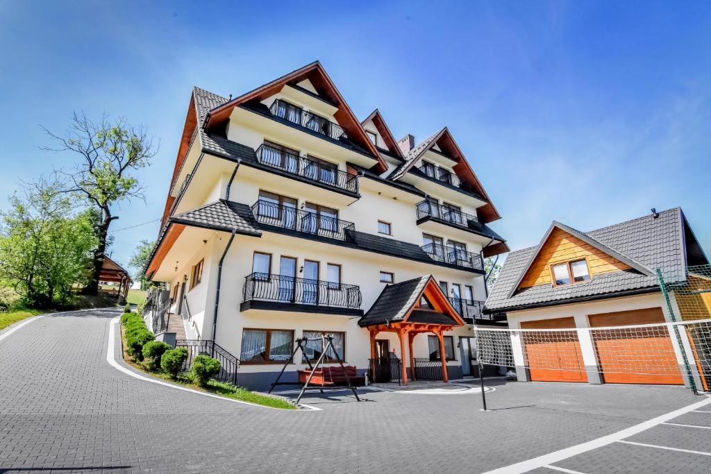 a large apartment building with a parking lot at Willa Stołowianka- Basen in Bukowina Tatrzańska