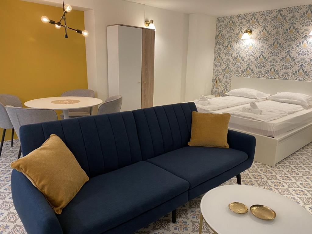 a living room with a blue couch and a bed at Gold Touch Studio in Timişoara