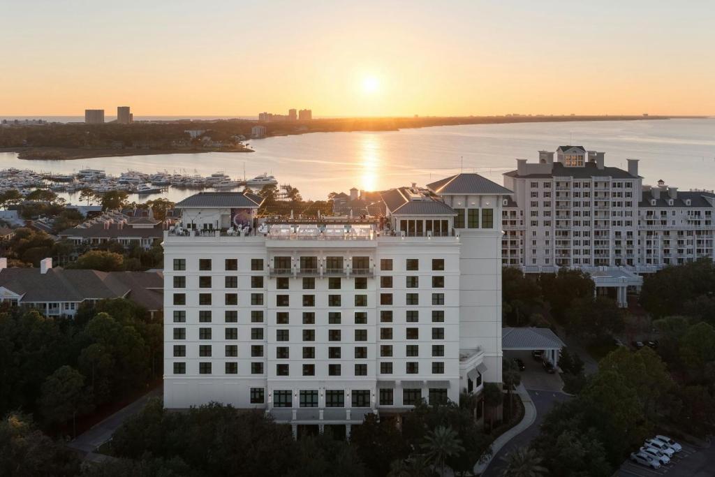 ein großes weißes Gebäude mit Sonnenuntergang im Hintergrund in der Unterkunft Hotel Effie Sandestin Resort, Autograph Collection in Destin