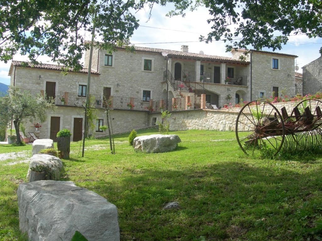 un grande edificio in pietra in un cortile con rocce di Agriturismo Borgo San Martino ad Abbateggio