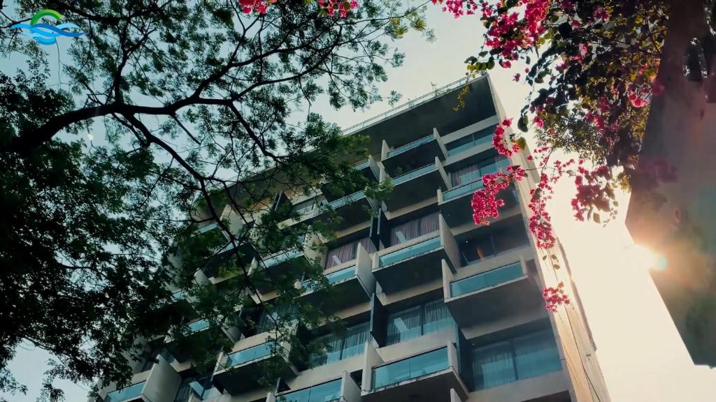 an office building with pink flowers in front of it at Coventina Lake Suites in Dhaka