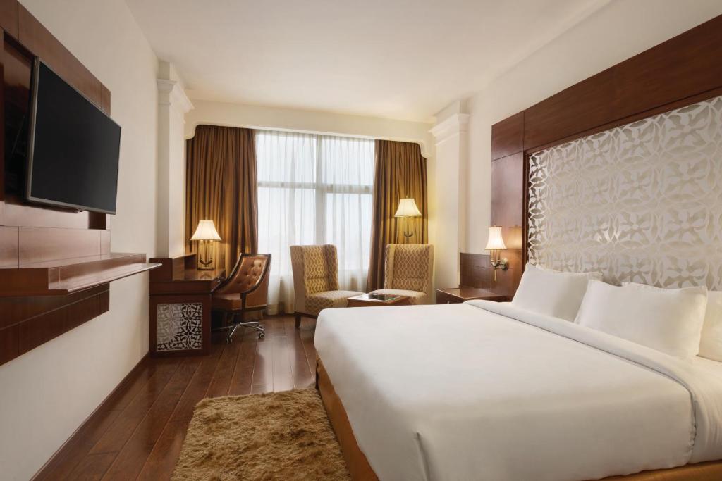a hotel room with a large bed and a desk at Ramada Plaza By Wyndham, Chandigarh Zirakpur in Chandīgarh