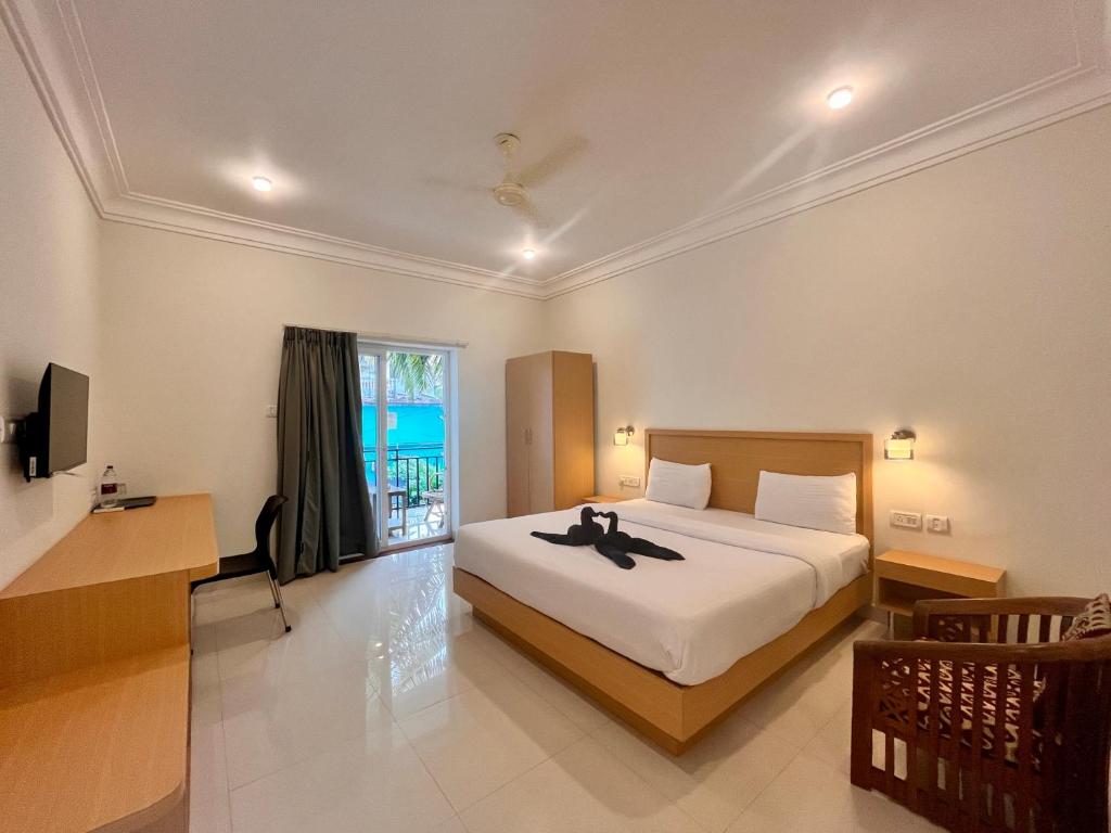 Una cama o camas en una habitación de Morjim Sunset Hotel - 400 meter to Morjim Beach