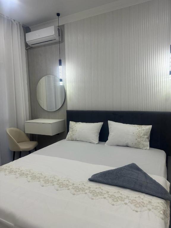 ein Schlafzimmer mit einem großen weißen Bett und einem Spiegel in der Unterkunft Двухкомнатная квартира в жилом доме ЖК Арман/ One-bedroom apartment in Arman residential complex in Atyrau
