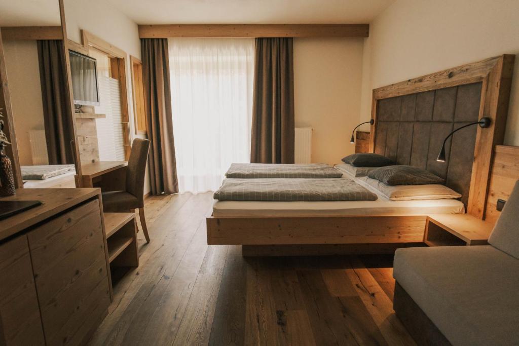a bedroom with a large bed with a wooden headboard at Pension Moarhof in Feldthurns