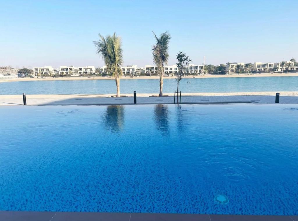 a large swimming pool with palm trees in the water at RAKvista Residence in Ras al Khaimah