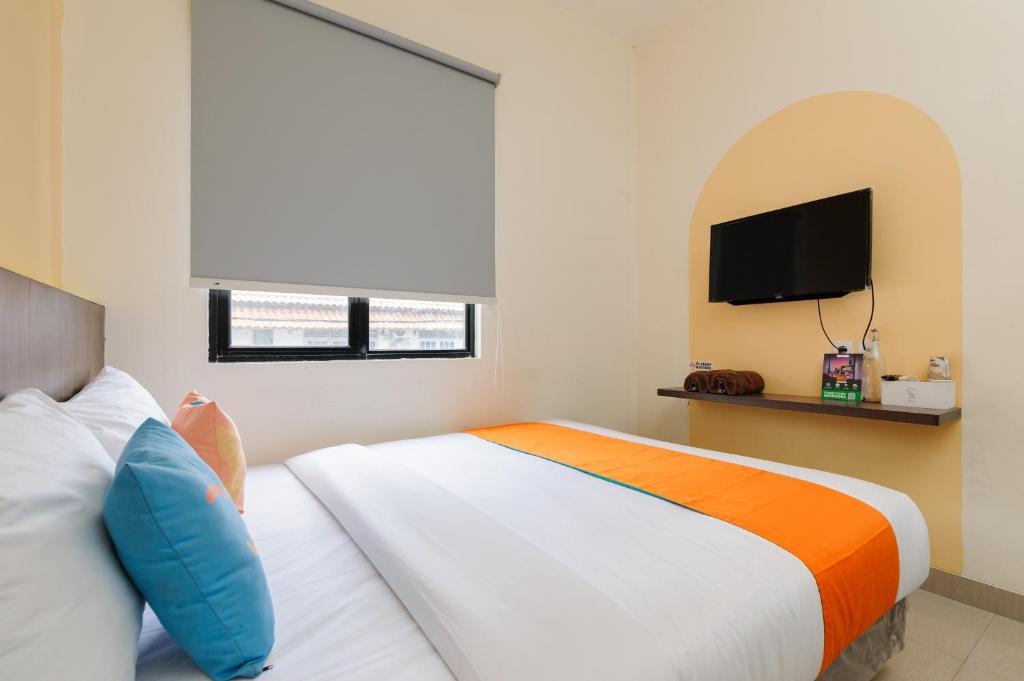 Postel nebo postele na pokoji v ubytování Sans Hotel Max Living Cengkareng