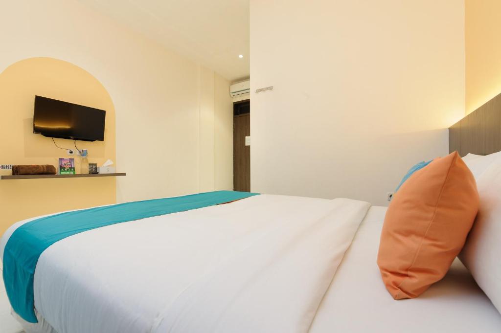 Postel nebo postele na pokoji v ubytování Sans Hotel Max Living Cengkareng