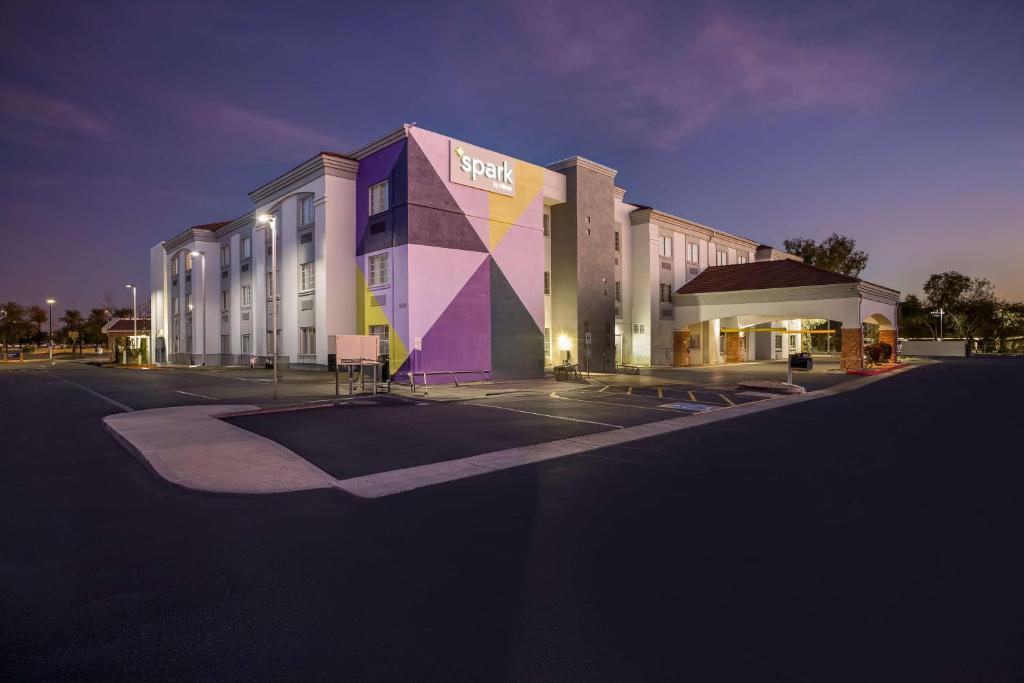 un grande edificio con una facciata colorata di notte di Spark by Hilton Phoenix-Glendale-Peoria a Glendale