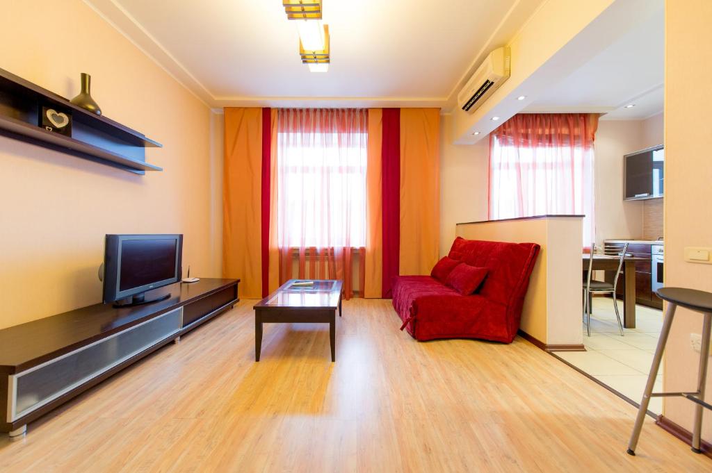 a living room with a red chair and a tv at Five Stars Revolution square in Chelyabinsk