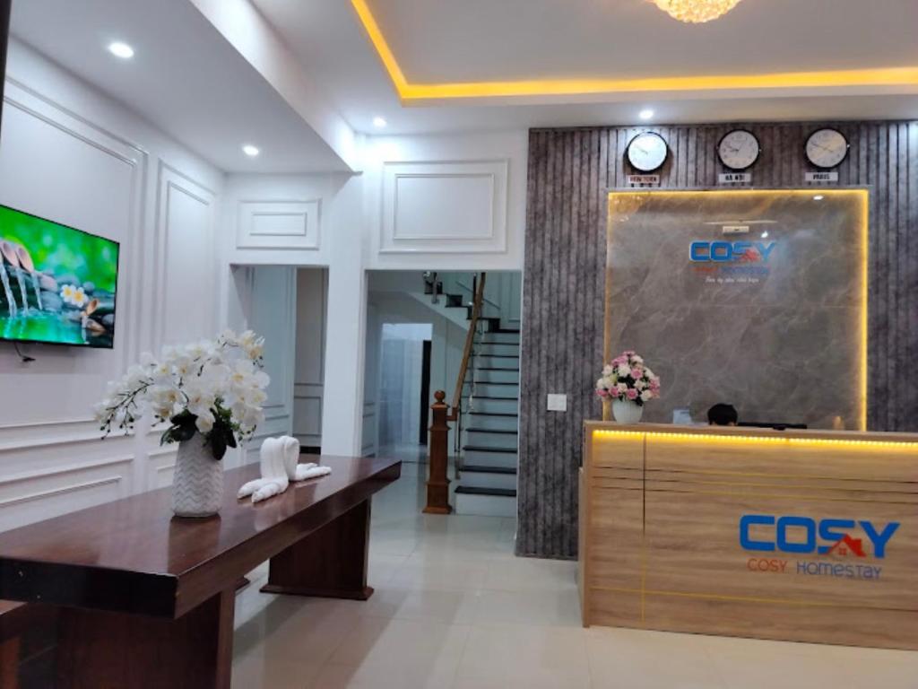 un hall d'entrée avec un bureau de réception et une horloge dans l'établissement Cosy Homestay Huế, à Hue
