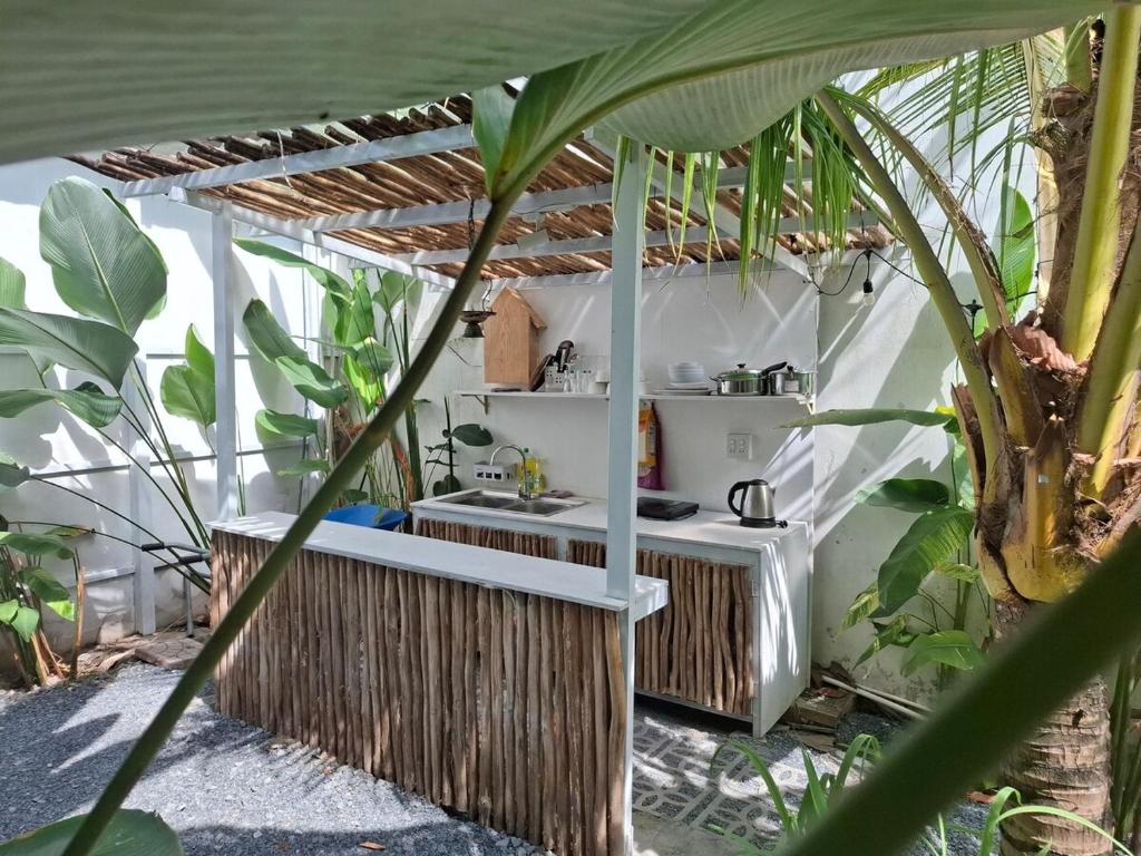 a bathroom with a sink in a room with plants at Pipo house, cool breeze, beautiful sunshine in Can Tho