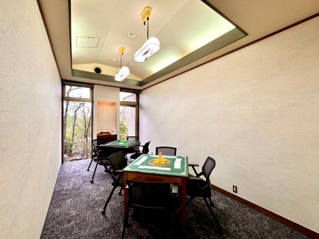 a room with two tables and chairs in it at 熱海山荘 in Atami