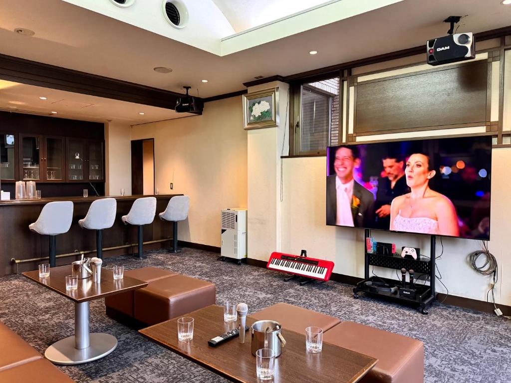a conference room with tables and a flat screen tv at 熱海山荘 in Atami