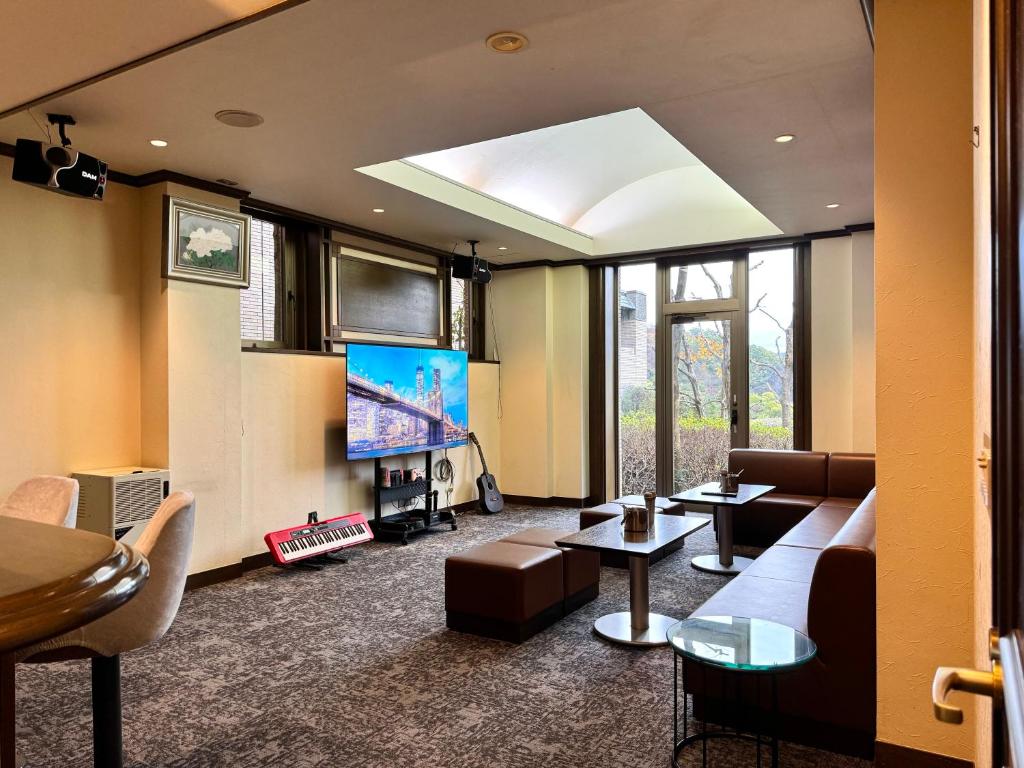 a living room with a couch and a flat screen tv at 熱海山荘 in Atami