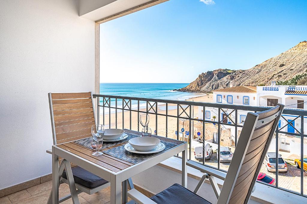 a table and chairs on a balcony with a view of the beach at Beach Apt 1 In Burgau in Burgau