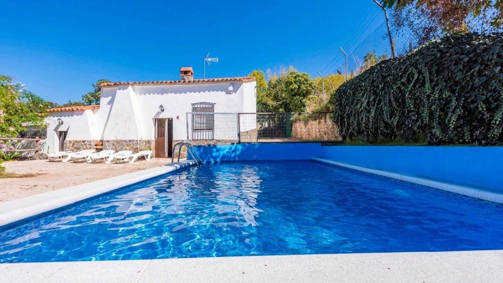 a swimming pool in front of a house at Parajes del Chanza Cortegana by Ruralidays in Cortegana